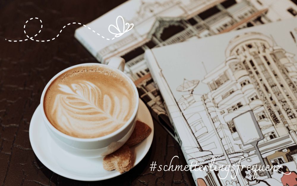 Tasse Cappuccino steht neben Bauplänen