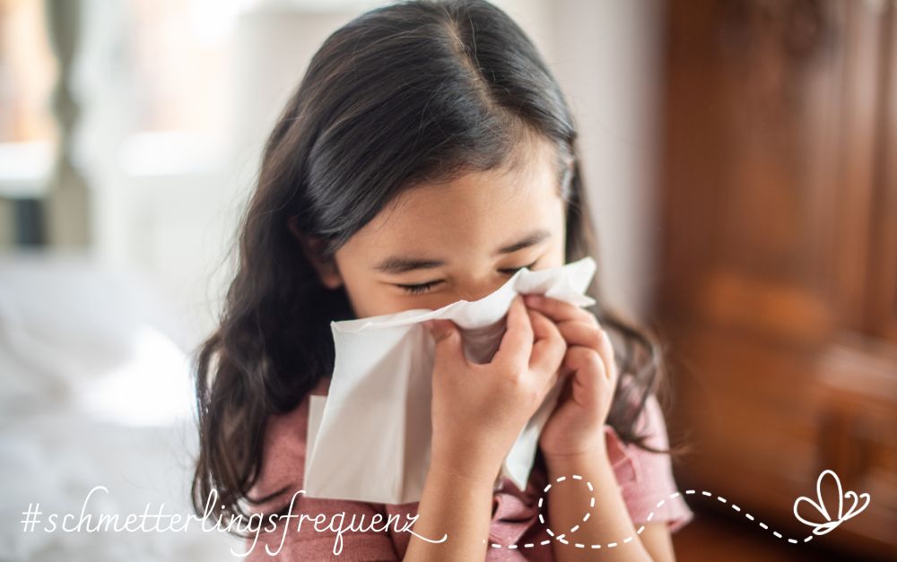 Gesundheit verstehen Erkaeltung Ein dunkelhaariges Mädchen niest in ein Papiertaschentuch