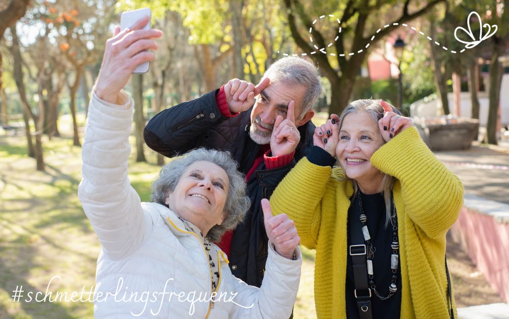 Ikigai, Gesundheit, langes Leben. 2 ältere Frauen und ein älterer Mann schneiden Grimassen für ein Selfie. Ikigai verlängert das Leben.