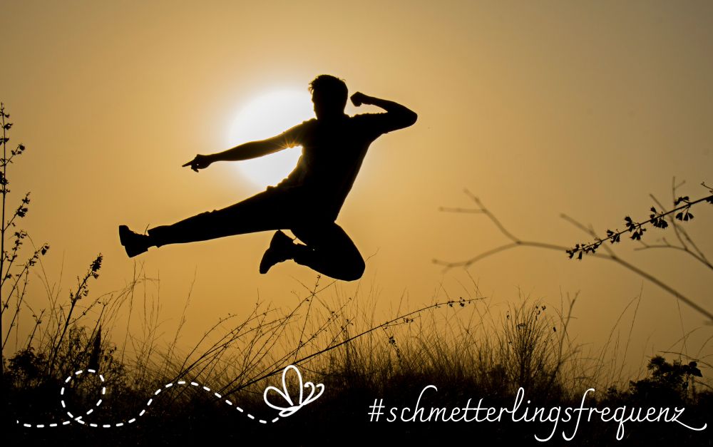 Selbstwert Freude Selbstwert stärken macht Freude. Ein Mann springt im Sonnenuntergang in die Höhe und wirft dabei ein Bein und einen Arm zur Seite.