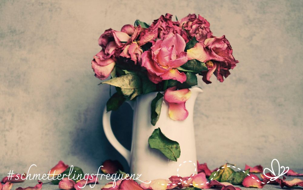 Ein verblühender Rosenstrauß in einer Vase. Selbstbestimmt sterben