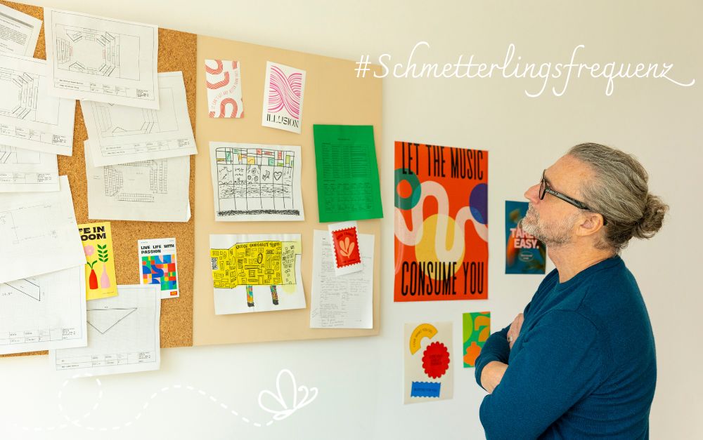 Mann betrachtet eine Pinnwand mit grafischen Elementen<br />
